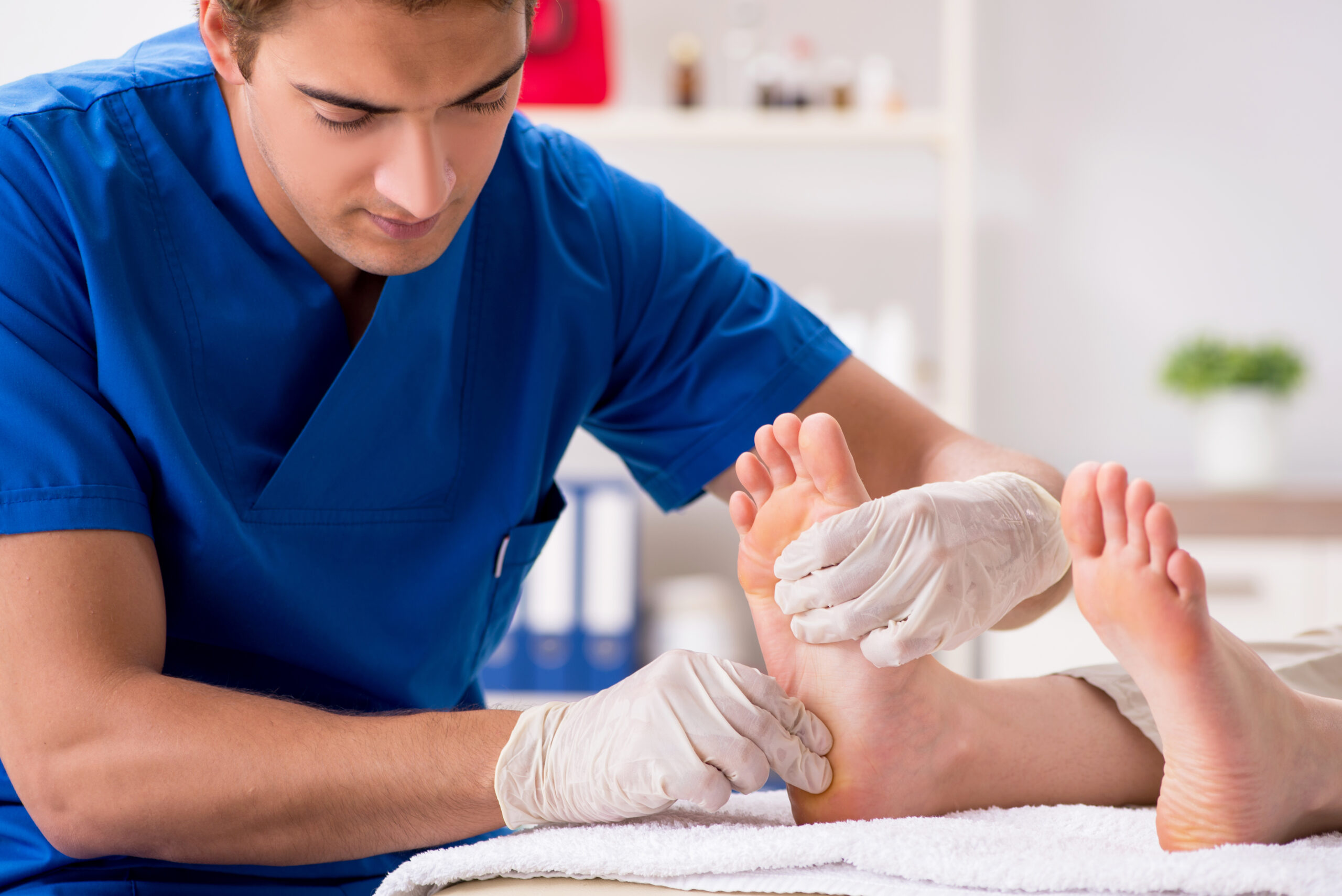 Podiatrist treating feet during procedure.